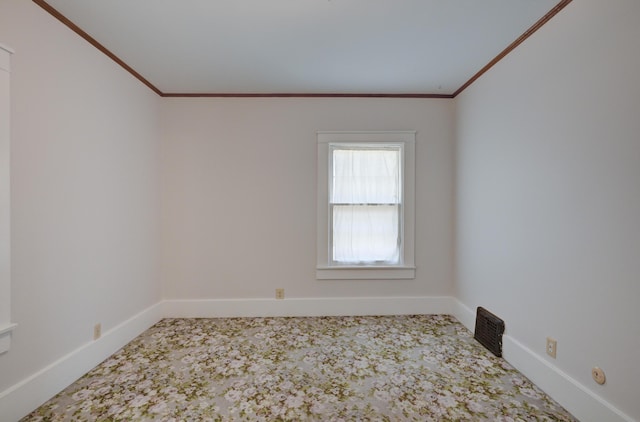 spare room featuring carpet flooring, ornamental molding, and baseboards