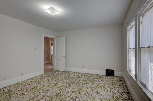 carpeted empty room with baseboards and visible vents