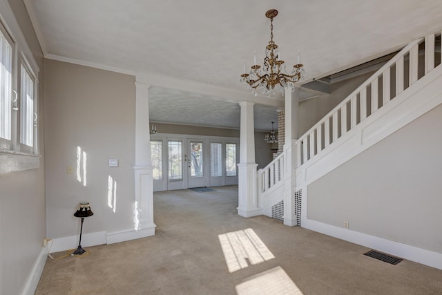 living area featuring stairway, ornate columns, carpet floors, visible vents, and a notable chandelier