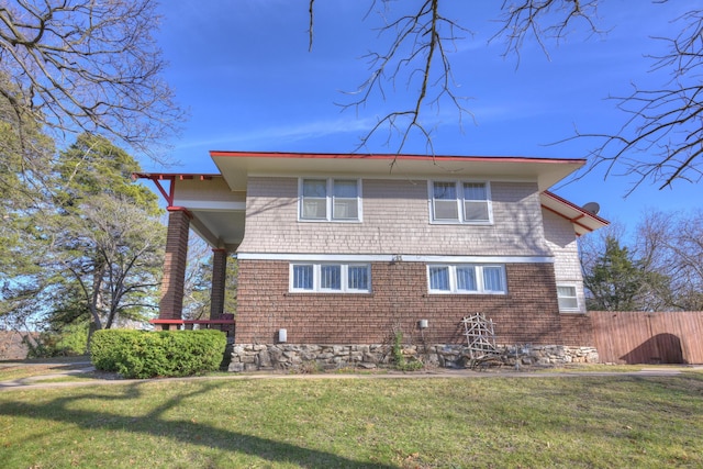 rear view of property featuring fence and a yard