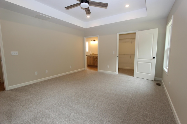 LOT1 Arden Rdg, Ava, MO 65608 - unfurnished bedroom featuring a tray ceiling, light carpet, a spacious closet, baseboards, and connected bathroom