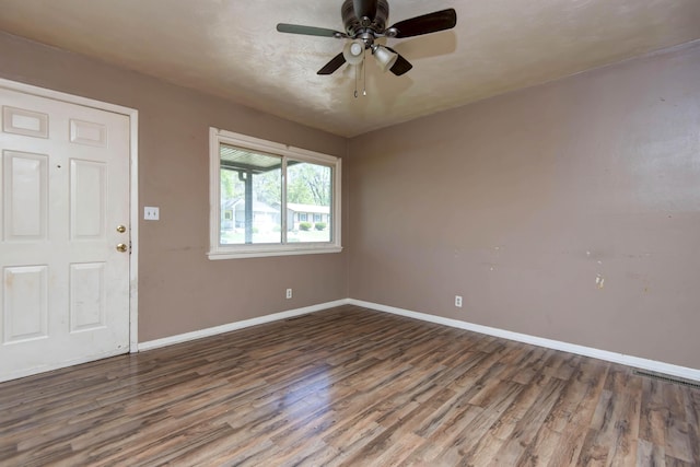 unfurnished room featuring visible vents, baseboards, a ceiling fan, and wood finished floors