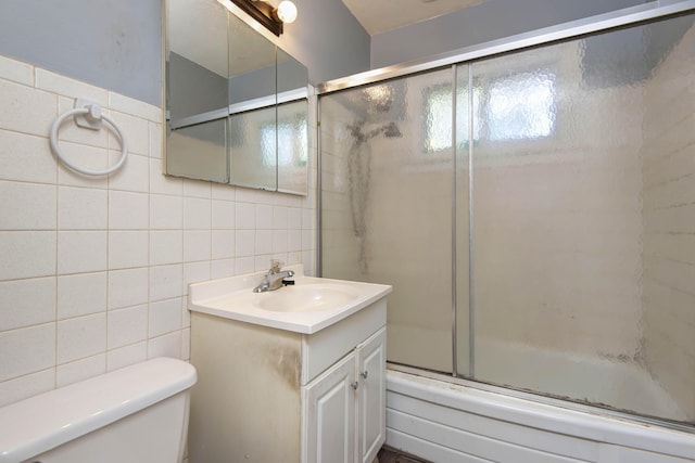 full bath featuring tasteful backsplash, vanity, tile walls, enclosed tub / shower combo, and toilet