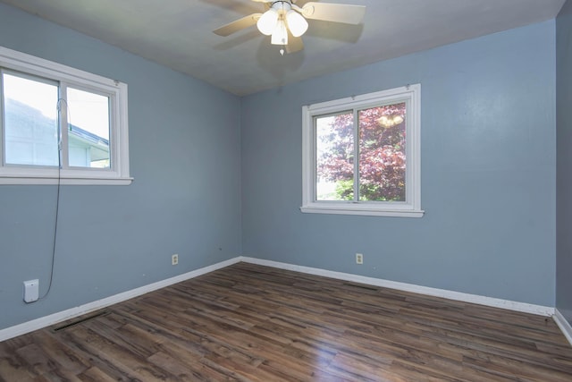 empty room with visible vents, baseboards, ceiling fan, and dark wood-style flooring