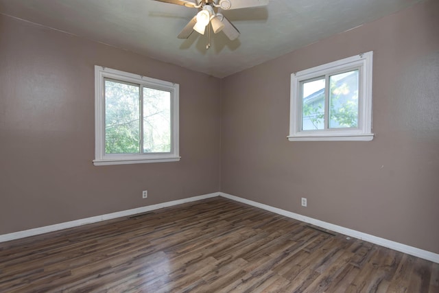 unfurnished room featuring a ceiling fan, baseboards, and dark wood-type flooring