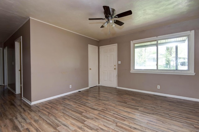 interior space with wood finished floors, visible vents, baseboards, and ceiling fan