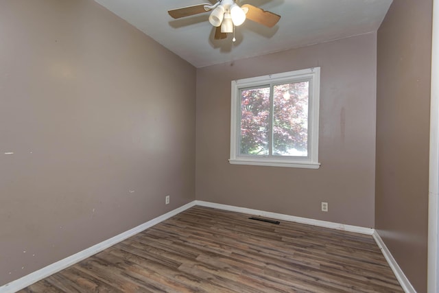 unfurnished room with wood finished floors, visible vents, a ceiling fan, and baseboards