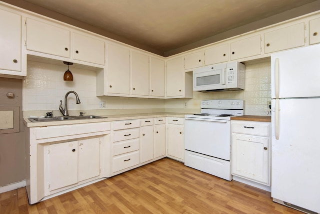 kitchen featuring tasteful backsplash, a sink, light wood-style flooring, white appliances, and light countertops