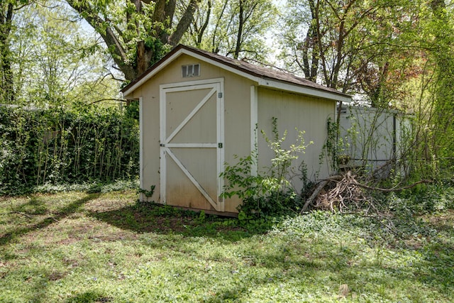 view of shed featuring fence