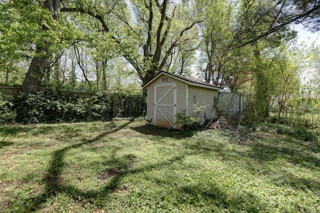 view of yard featuring a fenced backyard, an outbuilding, and a storage shed