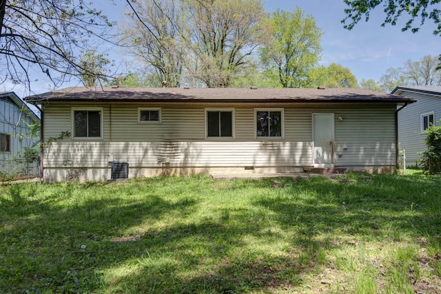 rear view of house with a lawn and cooling unit