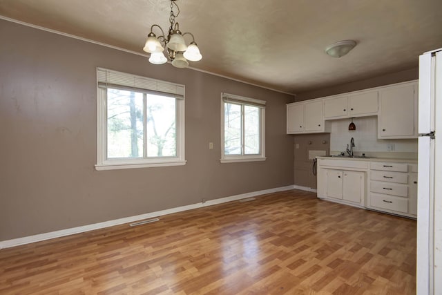 kitchen featuring a chandelier, light wood-type flooring, visible vents, and baseboards
