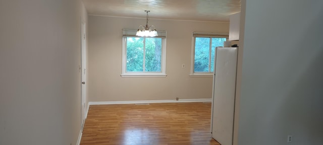 1022 E Mccanse St, Springfield, MO 65803 - empty room with a chandelier, wood finished floors, baseboards, and crown molding