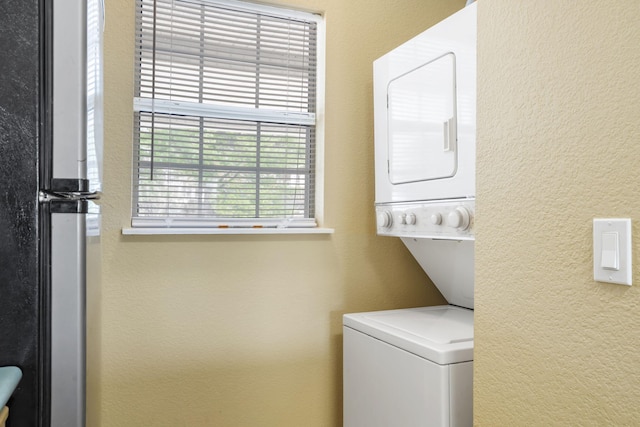 34 Golf Shrs Unit 26, Branson, MO 65616 - clothes washing area featuring stacked washer and clothes dryer, a textured wall, and laundry area