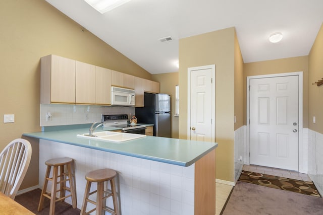 34 Golf Shrs Unit 26, Branson, MO 65616 - kitchen featuring a peninsula, light brown cabinets, electric range oven, white microwave, and freestanding refrigerator