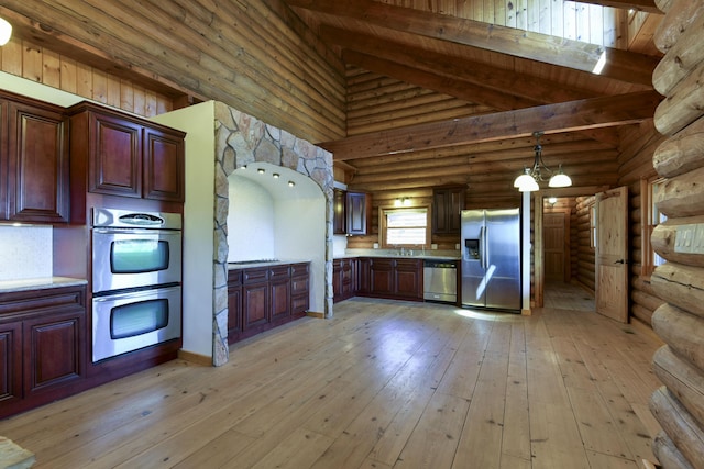 kitchen featuring high vaulted ceiling, light countertops, beam ceiling, appliances with stainless steel finishes, and light wood-type flooring