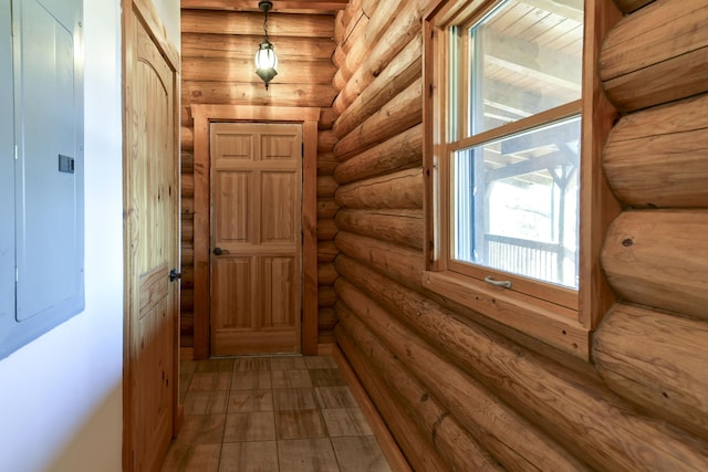 doorway to outside featuring electric panel and log walls