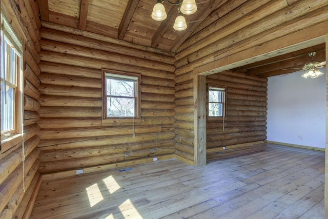 empty room featuring an inviting chandelier, log walls, wood ceiling, hardwood / wood-style flooring, and vaulted ceiling with beams