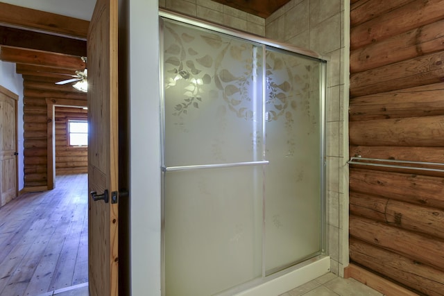 bathroom featuring hardwood / wood-style flooring, a stall shower, and ceiling fan