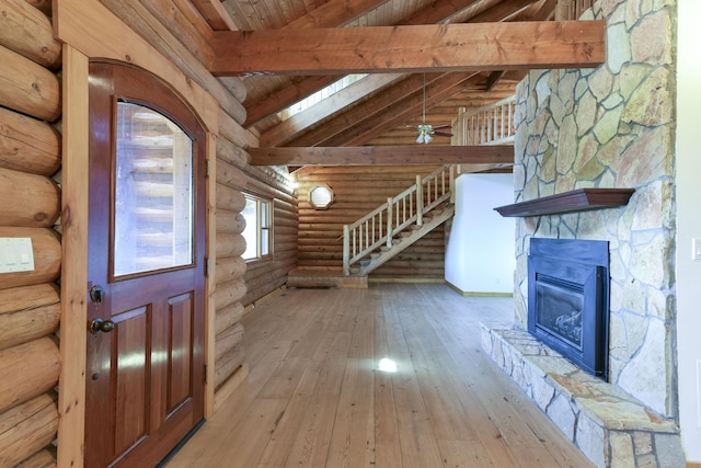 foyer with lofted ceiling with beams, a fireplace, a ceiling fan, hardwood / wood-style floors, and wood ceiling
