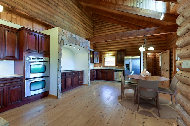 kitchen with high vaulted ceiling, light countertops, beam ceiling, appliances with stainless steel finishes, and light wood-style flooring