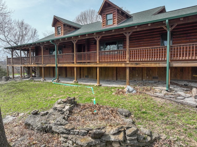 exterior space with roof with shingles, a yard, and log exterior