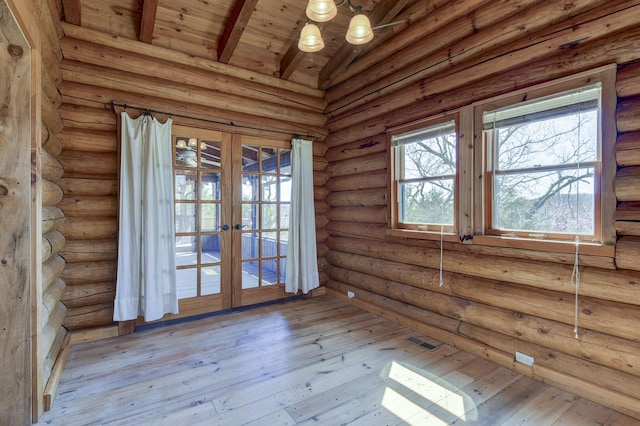 empty room featuring vaulted ceiling with beams, french doors, wooden ceiling, and hardwood / wood-style flooring
