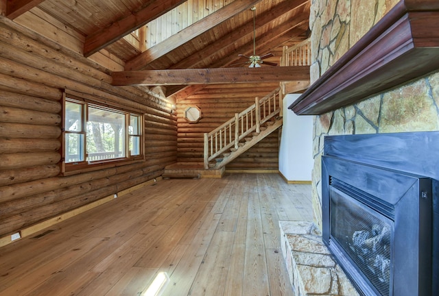 interior space with wooden ceiling, hardwood / wood-style flooring, lofted ceiling with beams, a stone fireplace, and rustic walls