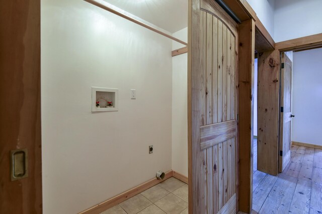 washroom featuring electric dryer hookup, hookup for a washing machine, baseboards, and laundry area