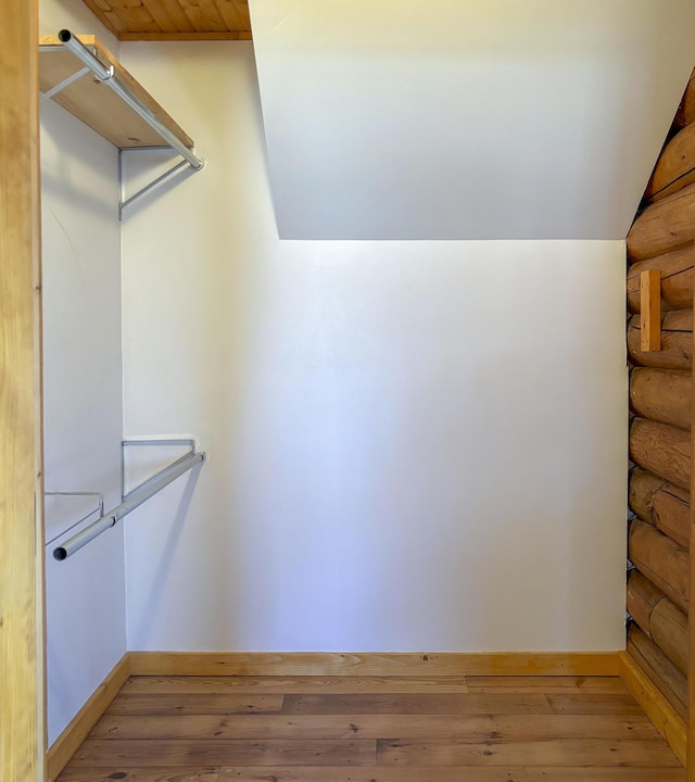 spacious closet with wood-type flooring and vaulted ceiling