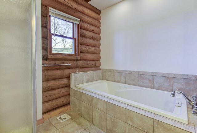 bathroom with tile patterned flooring and a garden tub