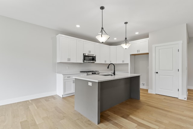 2117 N Silver Charm Ave, Springfield, MO 65802 - kitchen featuring stainless steel microwave, range, light wood-type flooring, recessed lighting, and white cabinetry