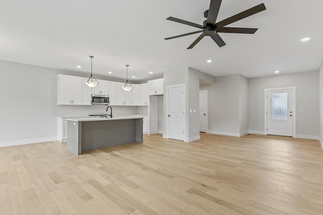2117 N Silver Charm Ave, Springfield, MO 65802 - kitchen with stainless steel microwave, ceiling fan, light countertops, open floor plan, and recessed lighting
