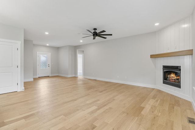 2117 N Silver Charm Ave, Springfield, MO 65802 - unfurnished living room featuring a fireplace, recessed lighting, a ceiling fan, and light wood-style floors