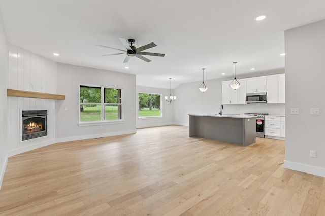 2117 N Silver Charm Ave, Springfield, MO 65802 - unfurnished living room featuring recessed lighting, a ceiling fan, a large fireplace, light wood-type flooring, and a chandelier