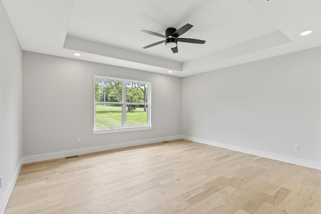 2117 N Silver Charm Ave, Springfield, MO 65802 - empty room featuring a raised ceiling, recessed lighting, light wood-style flooring, and a ceiling fan