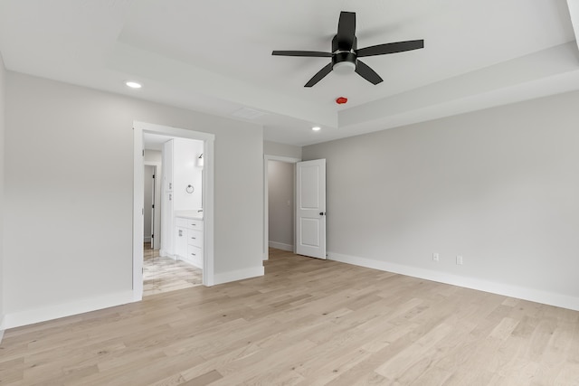 2117 N Silver Charm Ave, Springfield, MO 65802 - unfurnished bedroom featuring recessed lighting, light wood-style flooring, a raised ceiling, connected bathroom, and ceiling fan