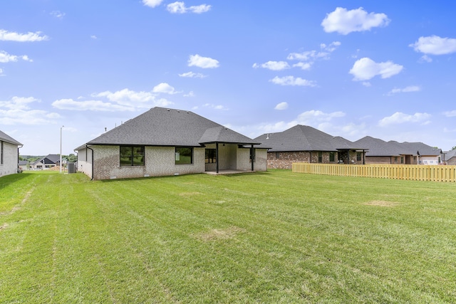 2117 N Silver Charm Ave, Springfield, MO 65802 - back of property featuring roof with shingles, a patio, and brick siding