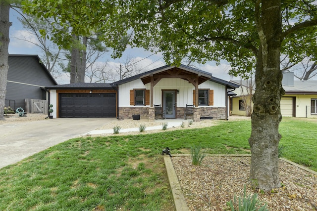 1428 Acacia Club Rd, Hollister, MO 65672 - view of front facade with board and batten siding, a front yard, fence, a garage, and driveway