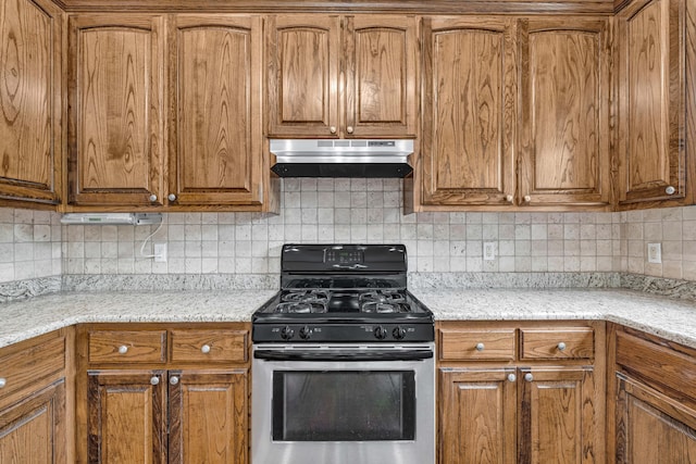 3607 Quail Run Rd, West Plains, MO 65775 - kitchen with gas range, under cabinet range hood, brown cabinets, decorative backsplash, and light stone counters
