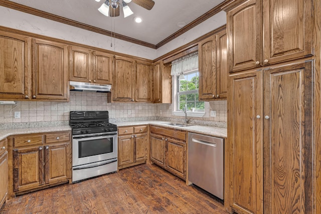 3607 Quail Run Rd, West Plains, MO 65775 - kitchen featuring appliances with stainless steel finishes, under cabinet range hood, a sink, brown cabinetry, and dark wood-style floors