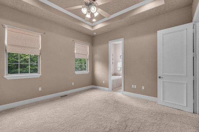 3607 Quail Run Rd, West Plains, MO 65775 - unfurnished bedroom featuring a tray ceiling, multiple windows, baseboards, and carpet
