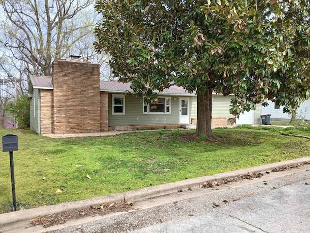 single story home featuring a chimney, a front lawn, and metal roof