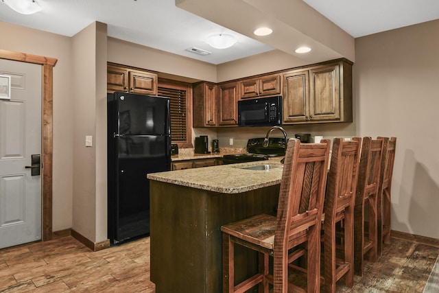 164 Dogwood Park Trl Bldg 1204, Branson, MO 65616 - kitchen with a kitchen breakfast bar, baseboards, light wood finished floors, visible vents, and black appliances