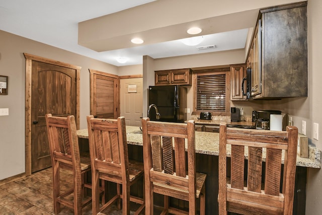 164 Dogwood Park Trl Bldg 1204, Branson, MO 65616 - kitchen featuring visible vents, baseboards, light stone countertops, a kitchen bar, and freestanding refrigerator