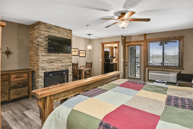 164 Dogwood Park Trl Bldg 1204, Branson, MO 65616 - bedroom featuring access to outside, wood finished floors, a stone fireplace, an AC wall unit, and freestanding refrigerator