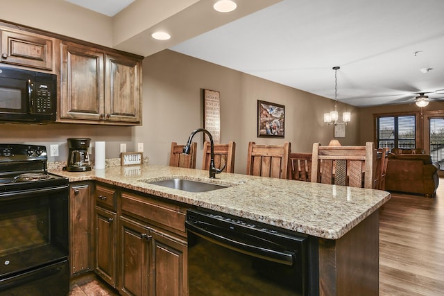 164 Dogwood Park Trl Bldg 1204, Branson, MO 65616 - kitchen with a sink, black appliances, a peninsula, and light stone counters