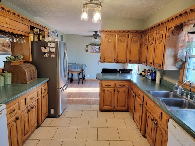 7 Lawrence Unit 2200, Wentworth, MO 64873 - kitchen featuring a sink, freestanding refrigerator, brown cabinets, white dishwasher, and a textured ceiling