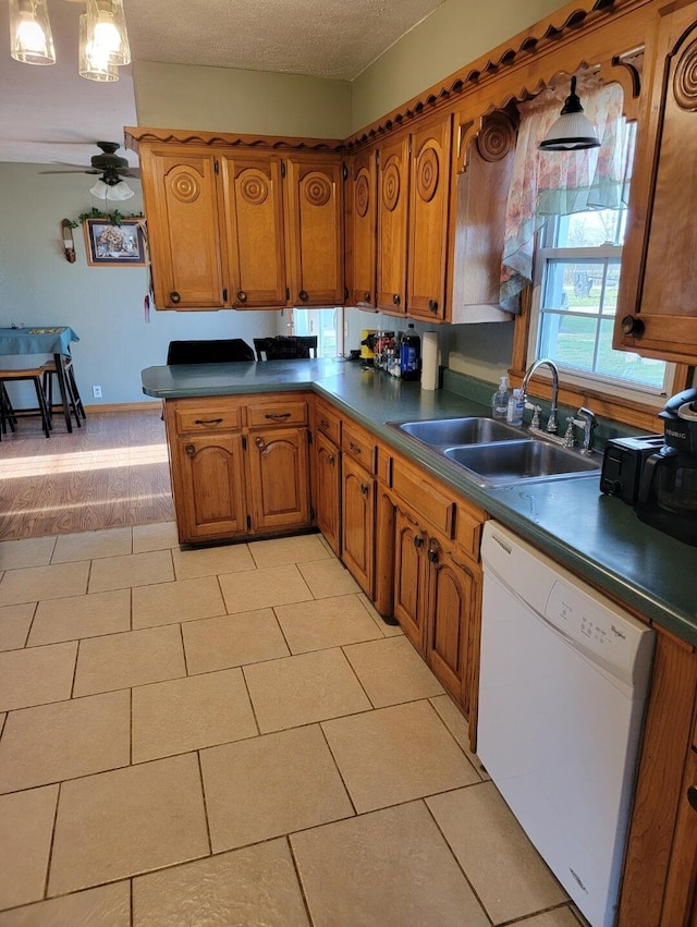 7 Lawrence Unit 2200, Wentworth, MO 64873 - kitchen with white dishwasher, a sink, brown cabinetry, a ceiling fan, and dark countertops