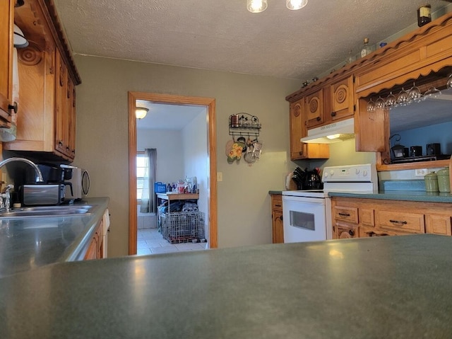 7 Lawrence Unit 2200, Wentworth, MO 64873 - kitchen with white range with electric cooktop, under cabinet range hood, a sink, brown cabinets, and a textured ceiling